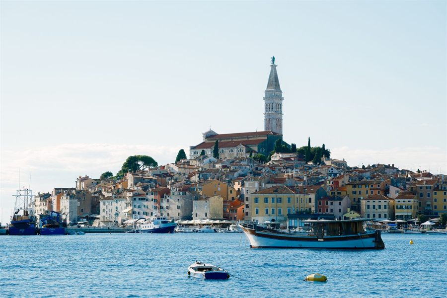 Old harbor town with a church tower by the sea