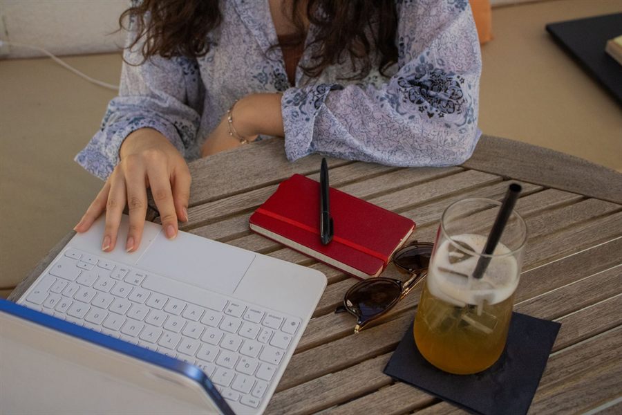 Woman typing on a tablet at a cafe table