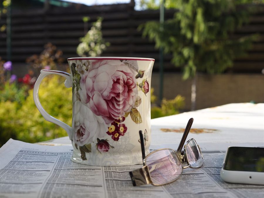 Mug and glasses resting on a newspaper